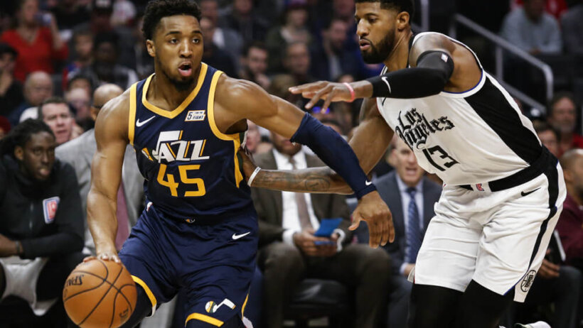 Donovan Mitchell driving with Paul George defending him