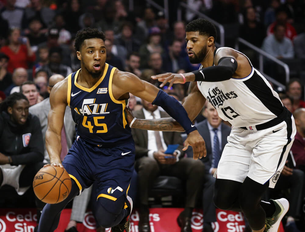 Donovan Mitchell driving with Paul George defending him