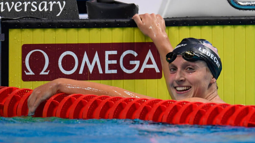 Katie Ledecky in the pool holding on to the edge