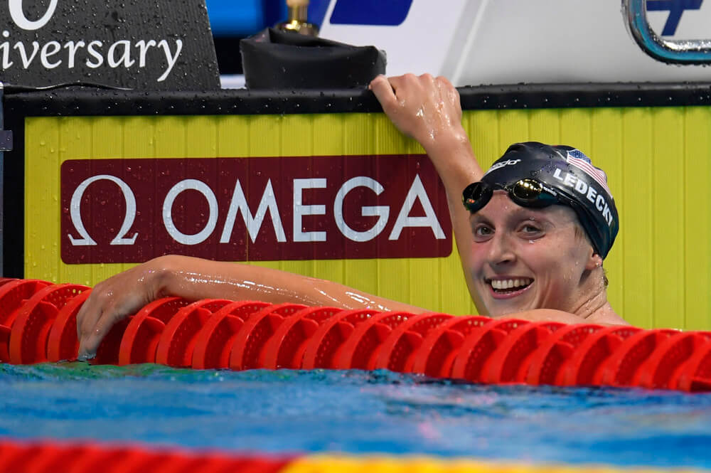 Katie Ledecky in the pool holding on to the edge