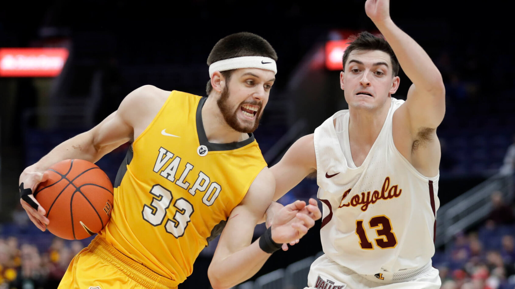 Valparaiso's John Kiser driving to the basket against Loyola's Clayton Custer in a NCAA men's basketball game.