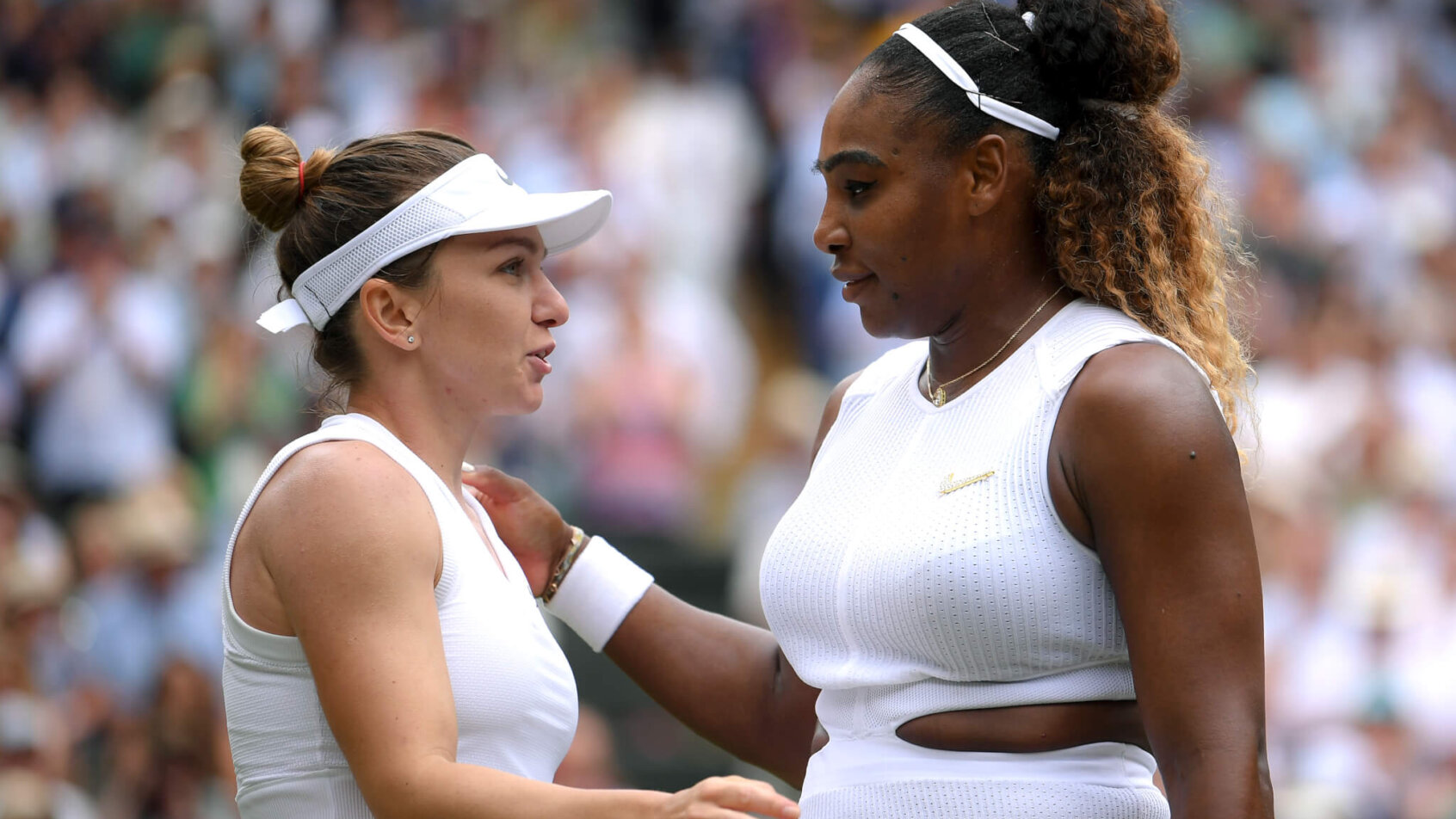 Simona Halep and Serena Williams going in for a hug on the court right after a match between the two.