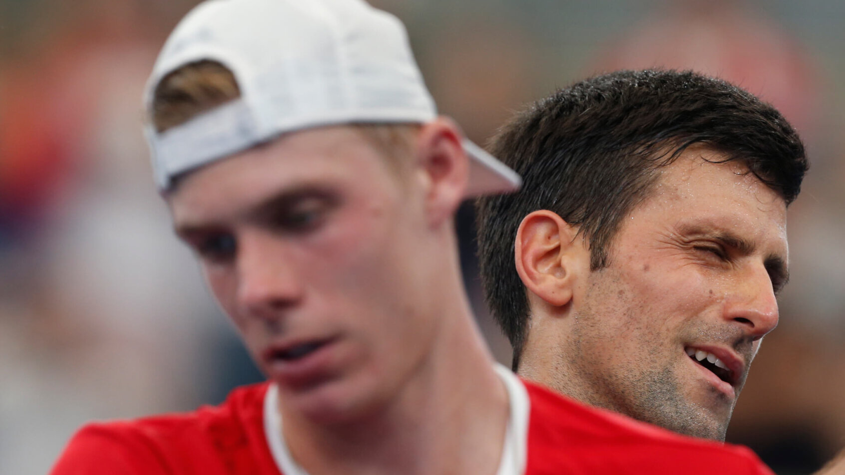 A close up of Novak Djokovic and Denis Shapovalov during a match at the ATP Cup.