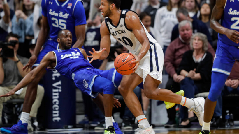 Bryce Nze driving as defender falls in front of him