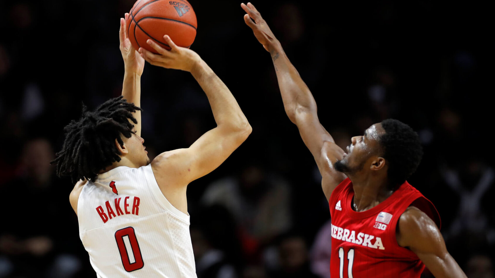 Rutgers guard Geo Baker taking a shot over Nebraska guard Dachon Burke Jr. during a NCAA men's basketball game.