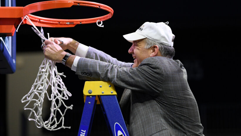 Hofstra head coach Joe Mihalich cutting the netting of the basket off after winning the championship.
