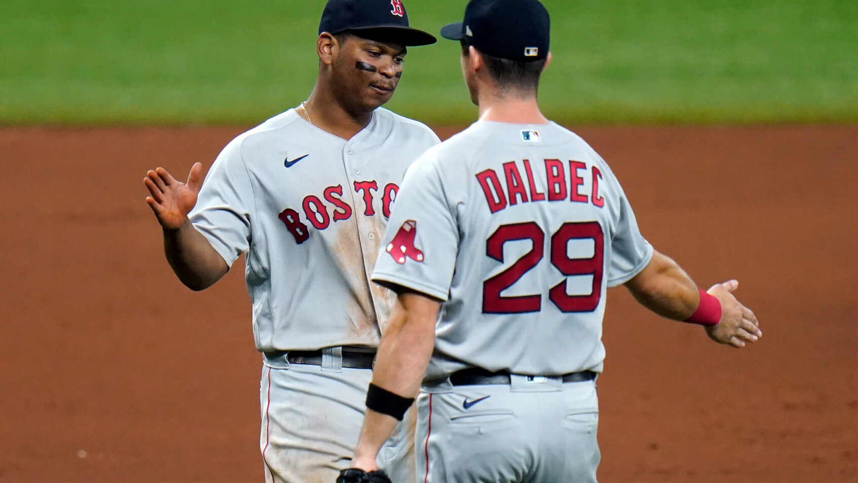 Boston Red Sox third baseman Rafael Devers hig-fiving teammate Bobby Dalbec