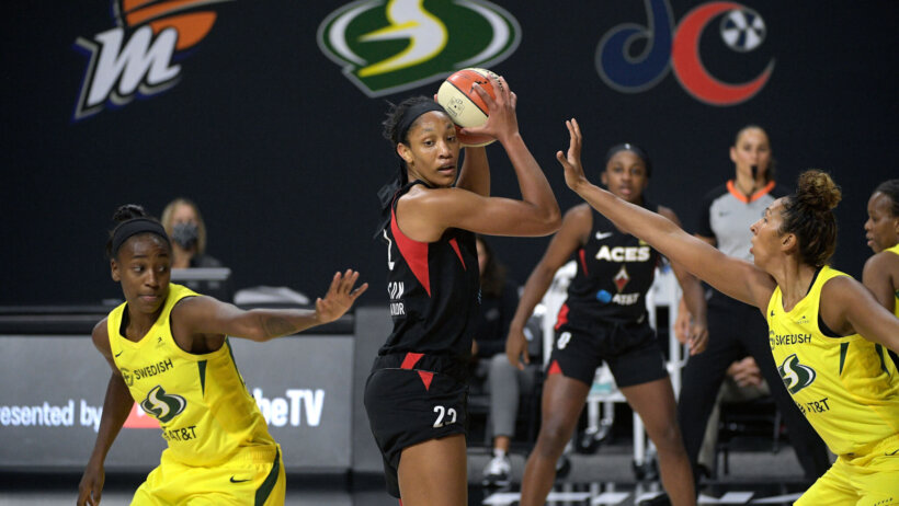 A'ja Wilson is defended by two Seattle players