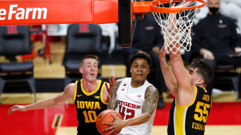 Rutgers guard Jacob Young going up to the basket to score against Iowa guard Joe Wieskamp and center Luke Garza during a NCAA men's basketball game.