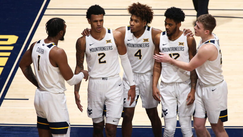 West Virginia's Derek Culver, Jalen Bridges, Miles McBride, Taz Sherman, and Sean McNeil all gather on the court during a NCAA men's basketball game.