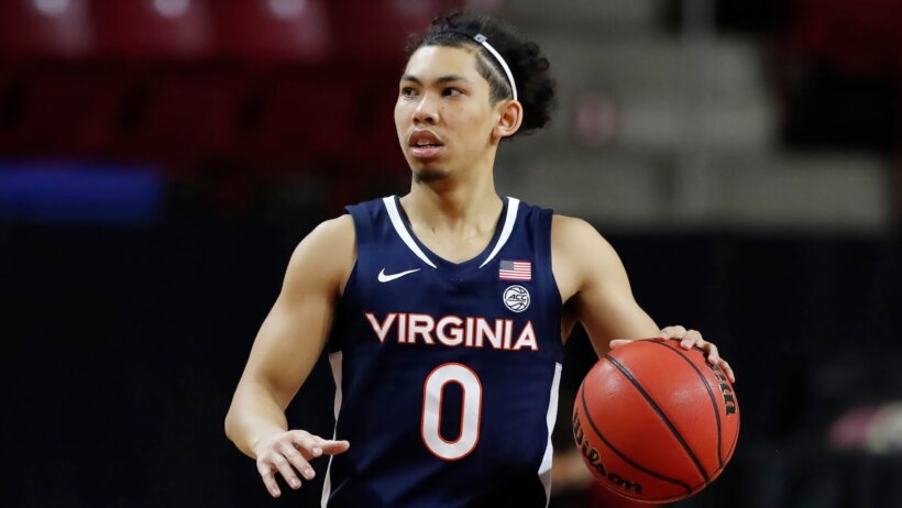 Virginia men's basketball player Kihel Clark dribbling the ball in the middle of a NCAA game.