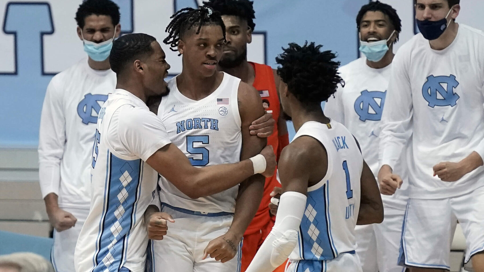 North Carolina men's basketball player Garrison Brooks celebrating with teammates during a NCAA game.