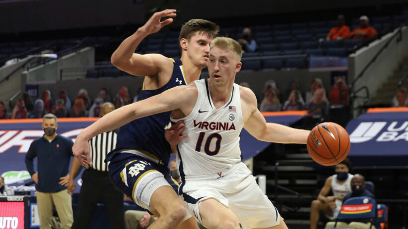 Virginia forward Sam Hauser dribbling the ball during a NCAA basketball game against Notre Dame.