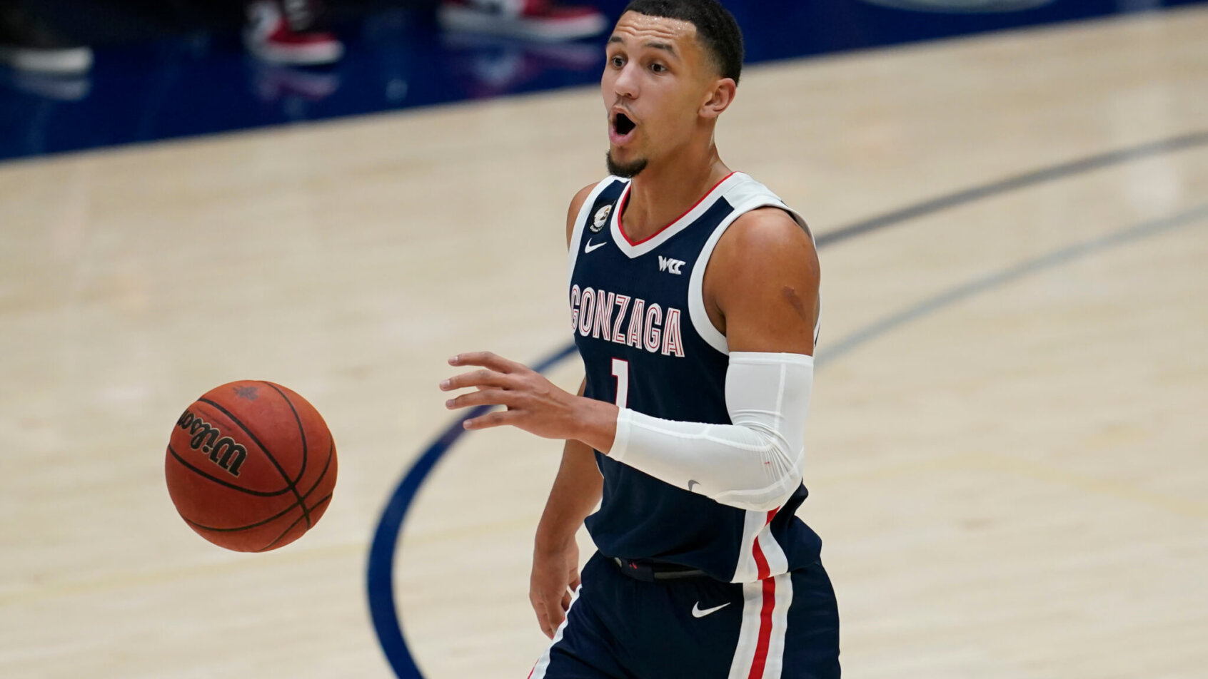 Gonzaga guard Jalen Suggs dribbling the ball up the court during a NCAA men's basketball game.