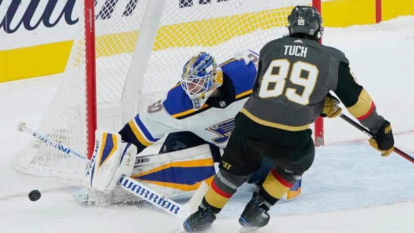 St. Louis Blues goaltender Jordan Binnington blocking a shot by Vegas Golden Knights right wing Alex Tuch during a shootout of an NHL game.