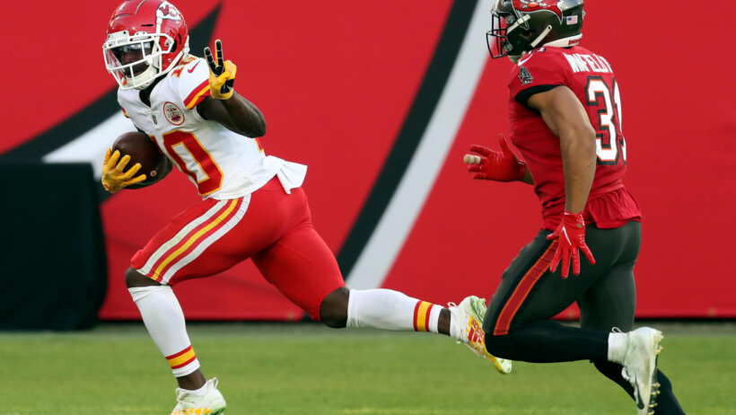 Tyreek Hill flashes peace sign while running past defender
