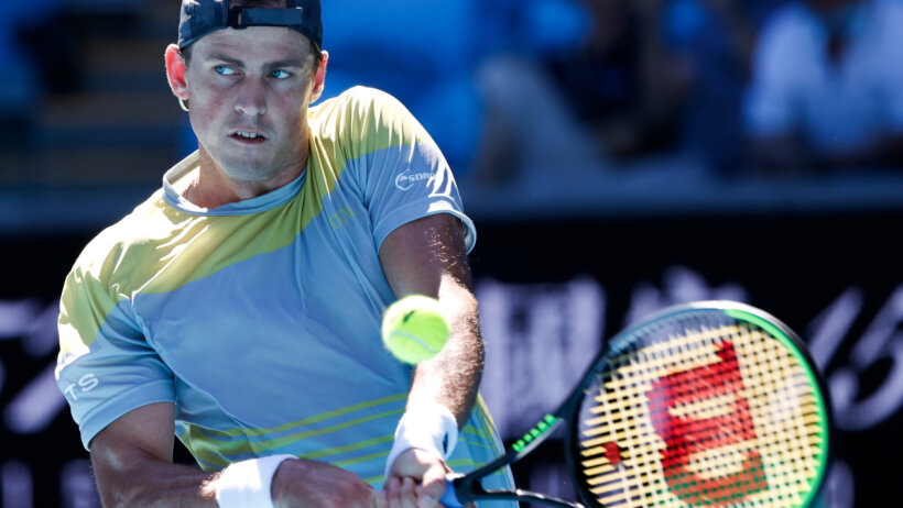 Vasek Pospisil making a backhand return during a tennis match.