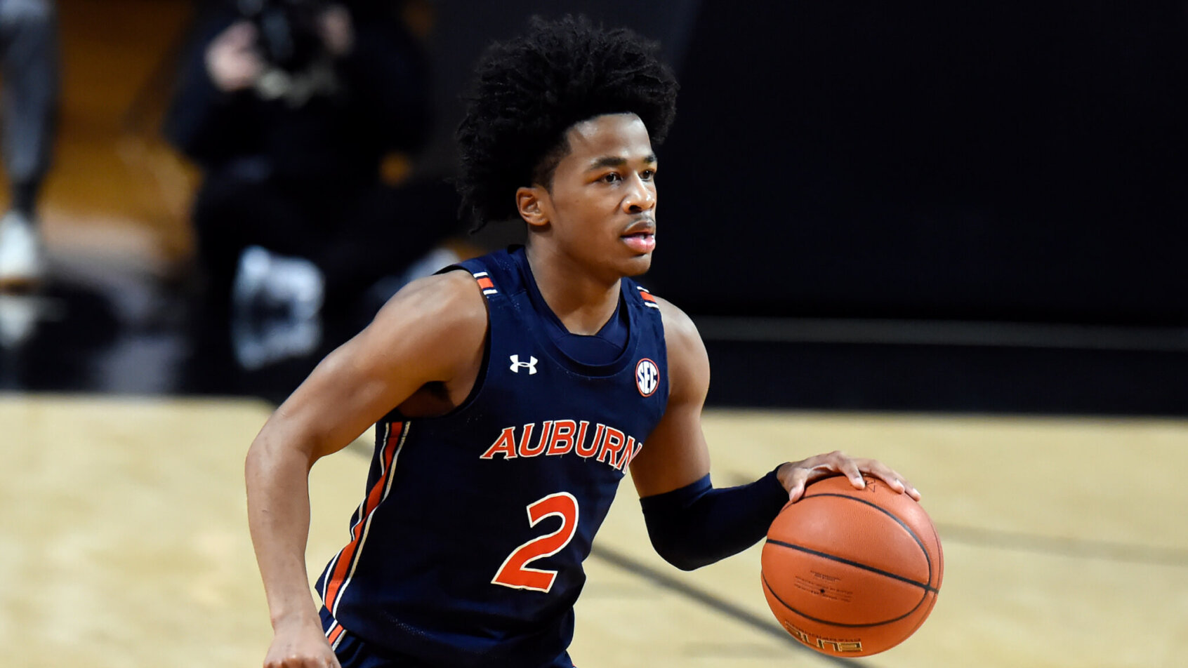Auburn guard Sharife Cooper dribbling the ball in the middle of a NCAA men's basketball game.
