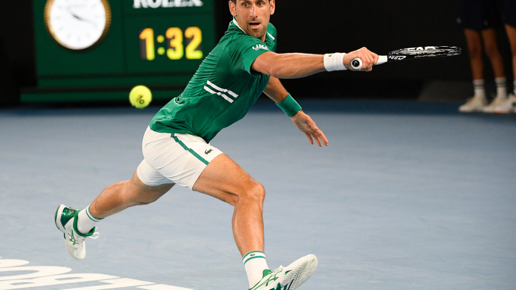 Novak Djokovic stretching to make a backhand return during a match at the 2021 Australian Open.