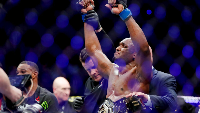 Kamaru Usman celebrates a title defense in the Octagon