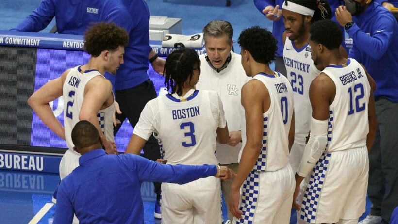 John Calipari with players huddled around him
