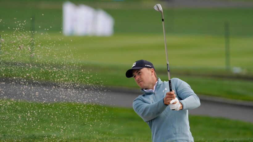 Jordan Spieth following through on his shot out of a bunker.