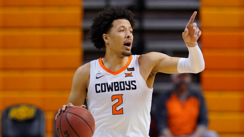 Oklahoma State guard Cade Cunningham calling a play dribbling up the court during a game.
