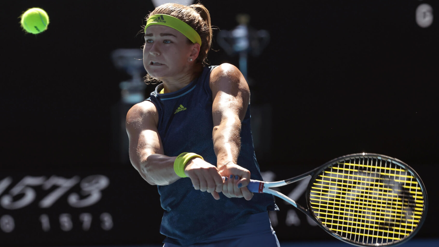 Karolina Muchova hitting a backhand return during a tennis match.