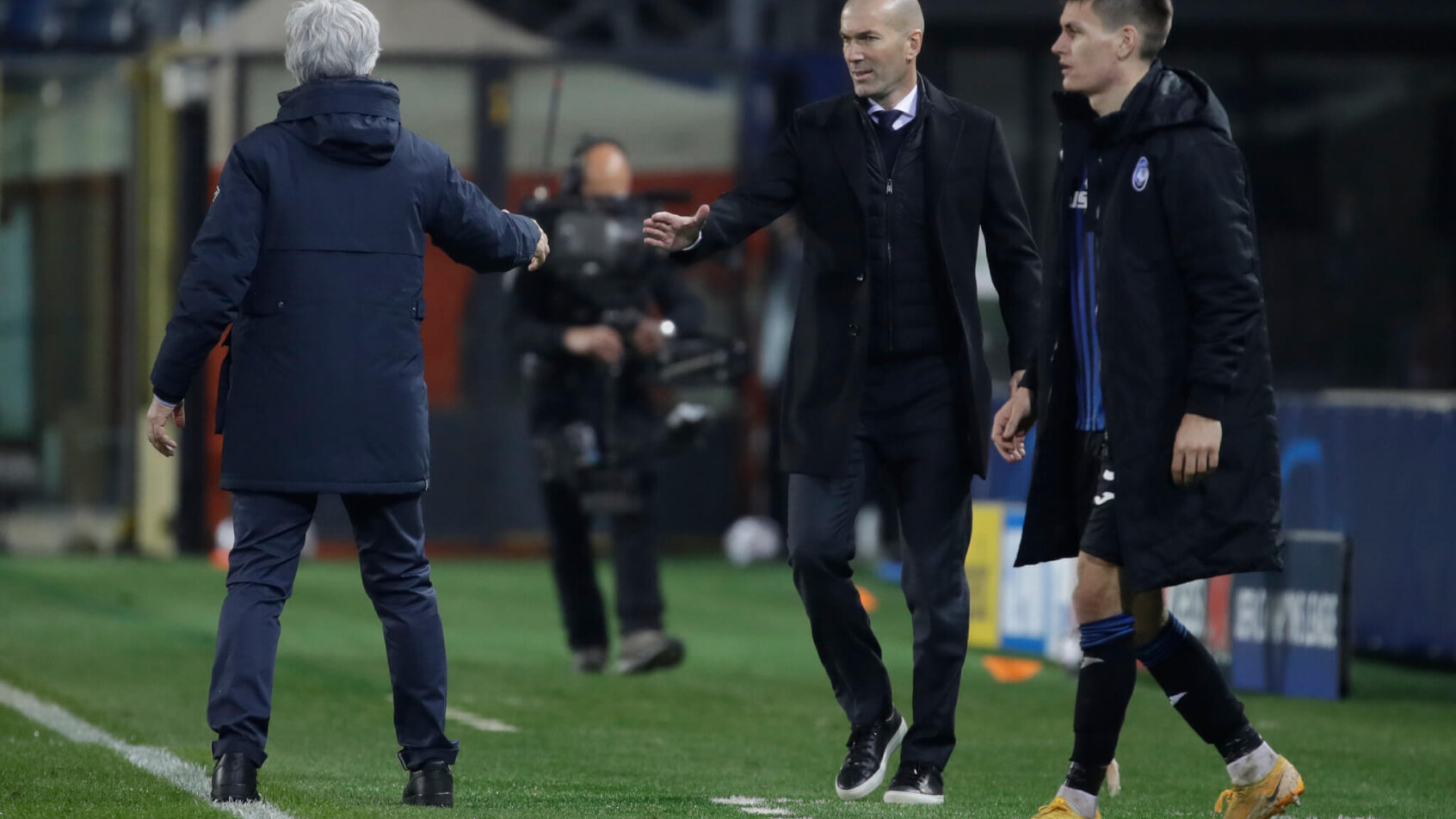 Real Madrid's head coach Zinedine Zidane going into shake hands with Atalanta's head coach Gian Piero Gasperini at the end of a match.