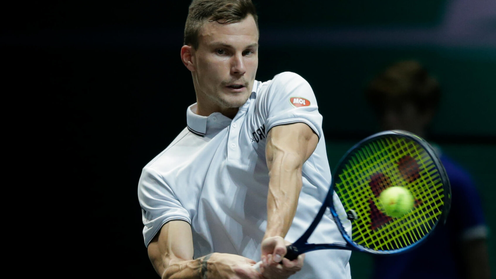 Marton Fucsovics of Hungary hitting a backhand shot during a tennis match.