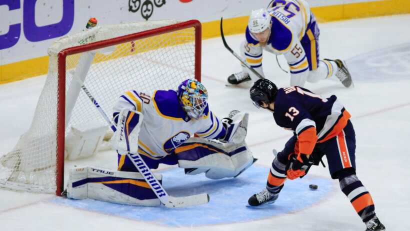 New York Islanders' Mathew Barzal scoring past Buffalo Sabres goaltender Carter Hutton in an NHL game.
