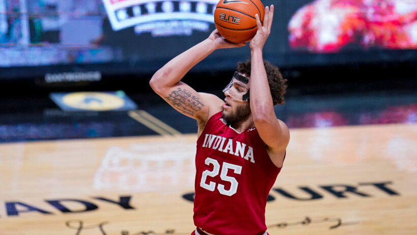 Race Thompson wearing protective face shield and shooting ball