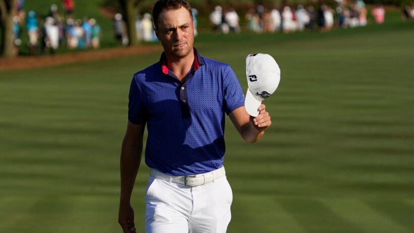 Justin Thomas holding hat