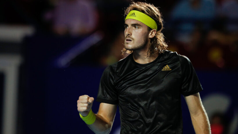 Stefanos Tsitsipas celebrating a point with a fist pump during a tennis match.