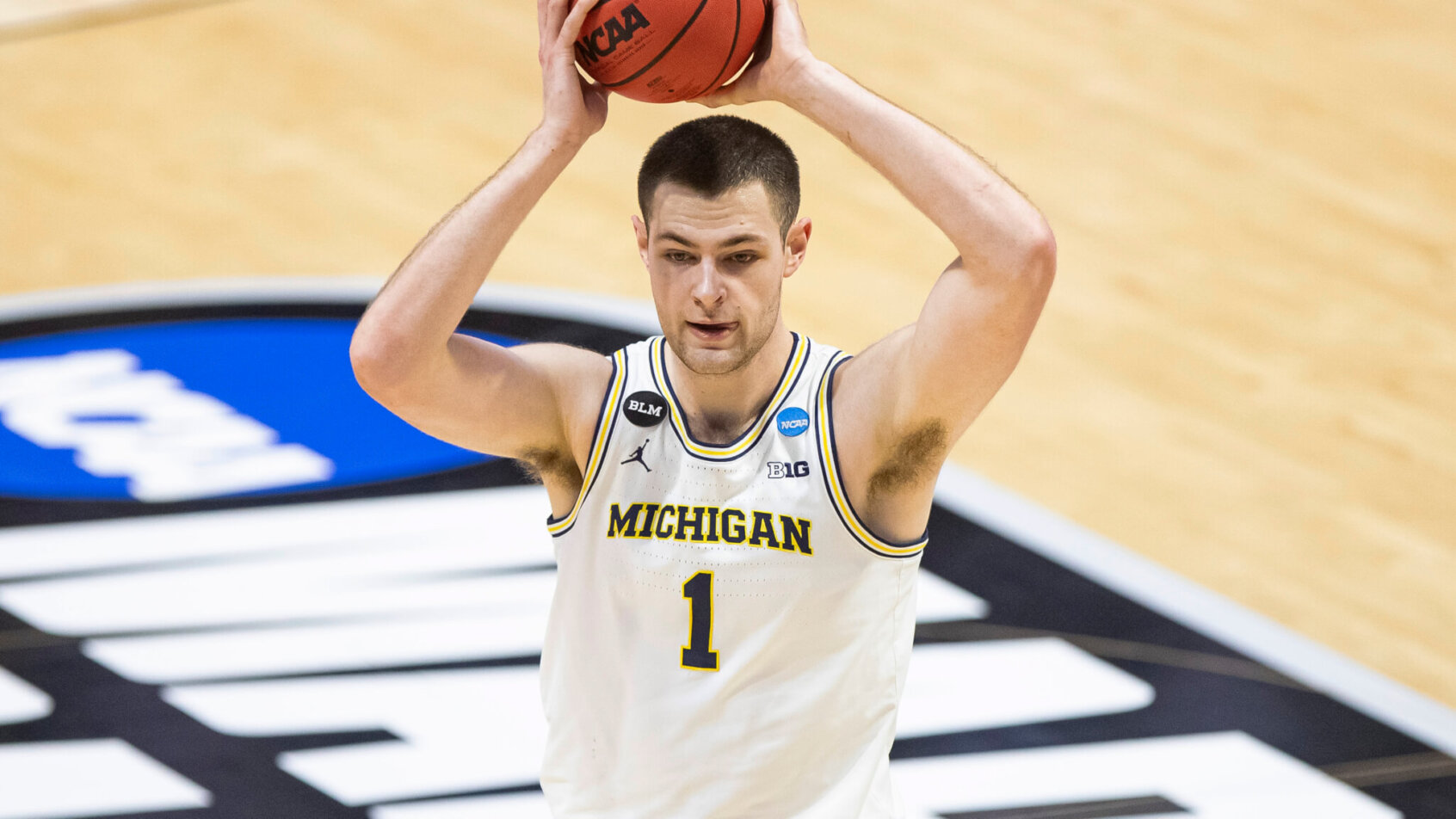 Michigan's Hunter Dickinson looking to pass the ball during a NCAA March Madness game.