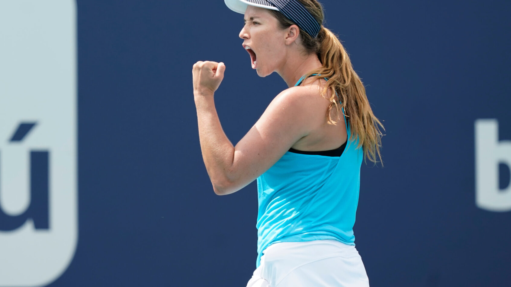Danielle Collins reacting with a fist bump and yelling after winning a point during a tennis match.