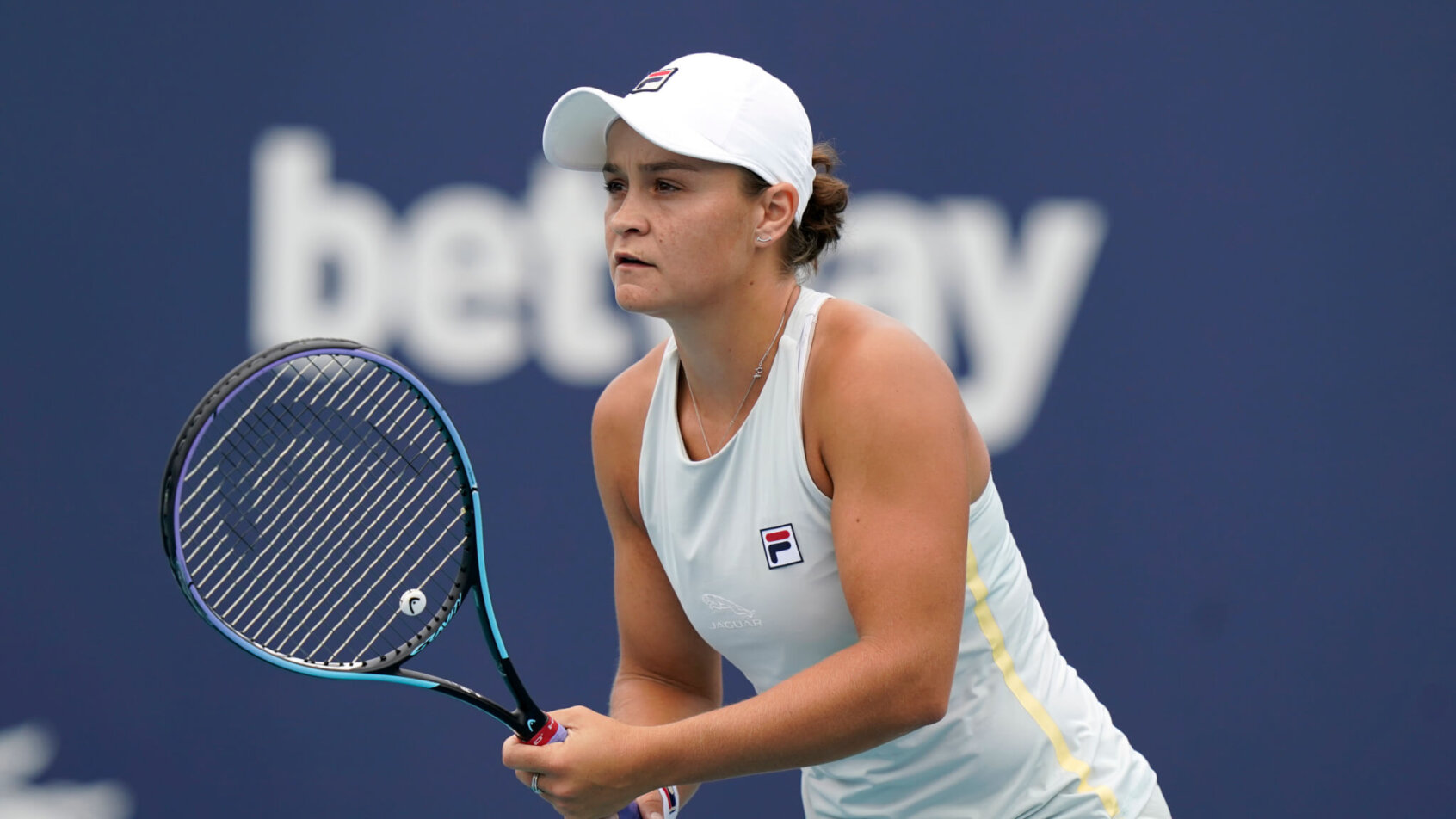 Ashleigh Barty waiting for a serve from her opponent during a tennis match.