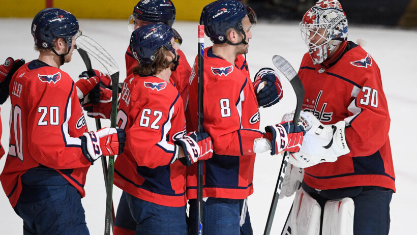 Washington Capitals players celebrating on the ice after an NHL game.