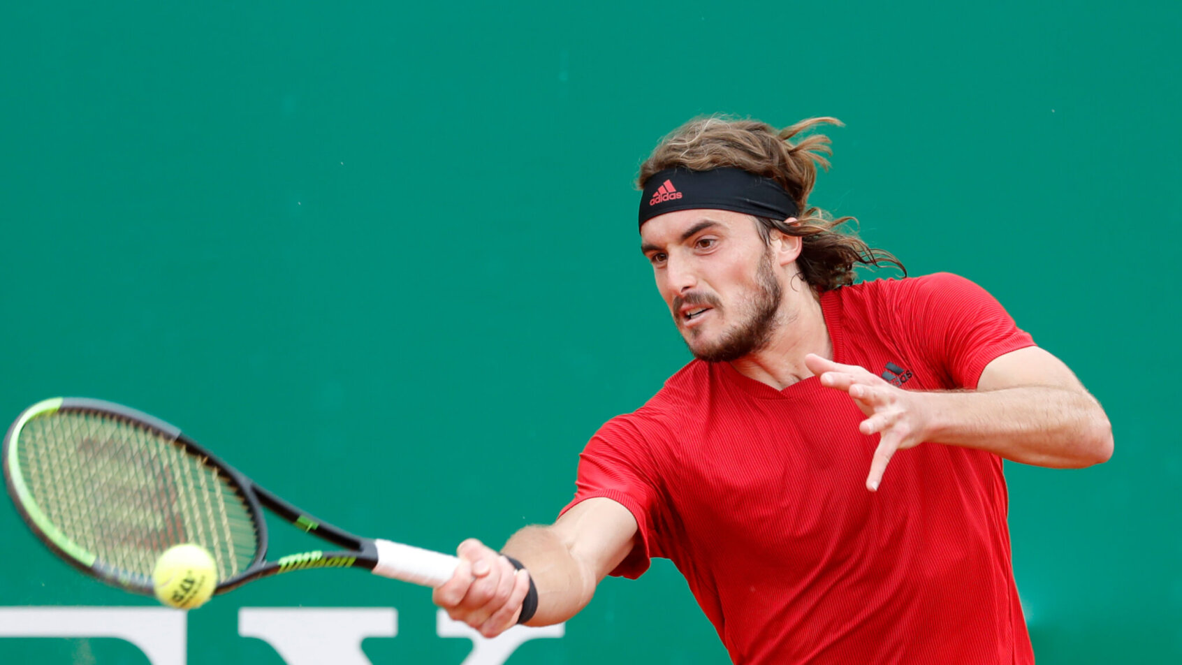 Stefanos Tsitsipas hitting a forehand return during a tennis match.