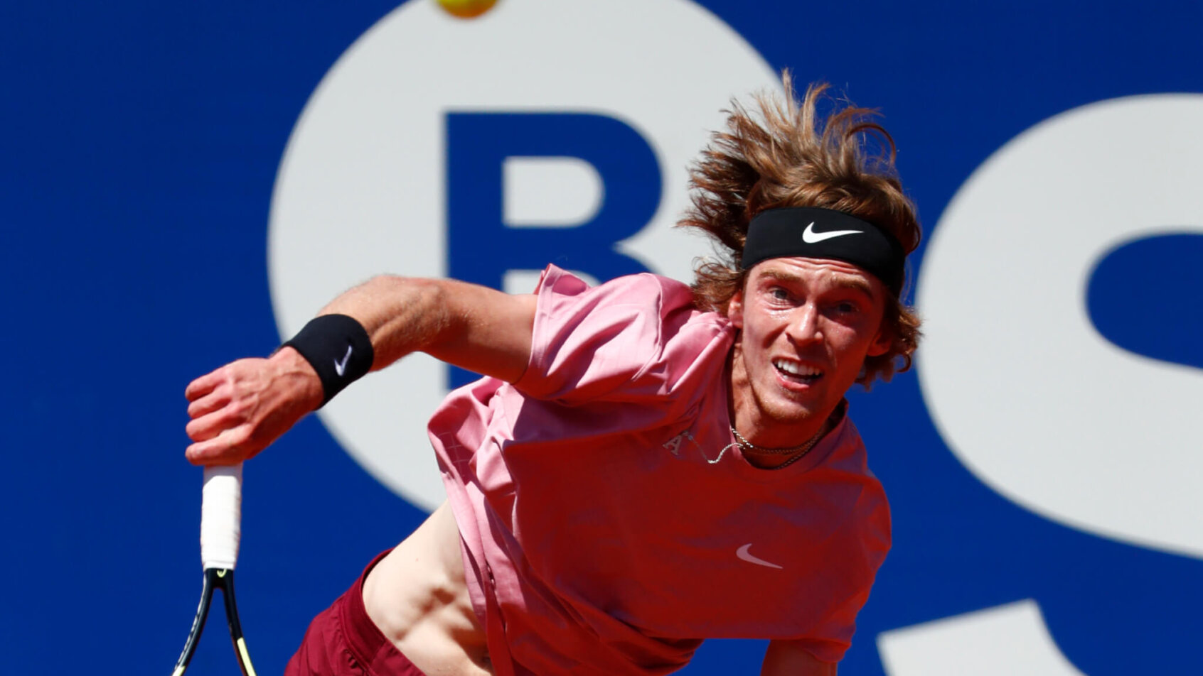 Andrey Rublev hitting a return during a tennis match.