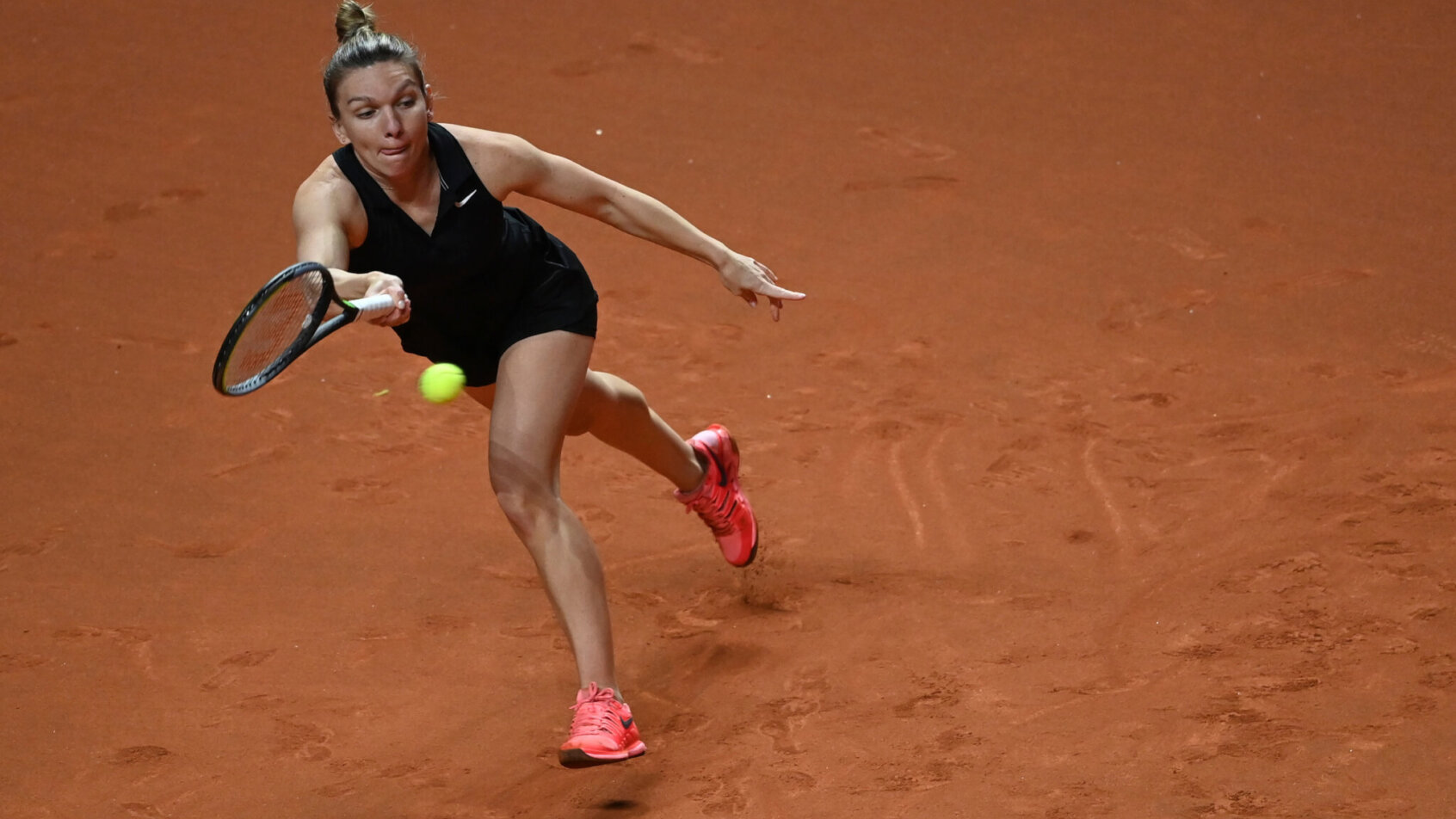 Simona Halep hitting a forehand return during a tennis match.