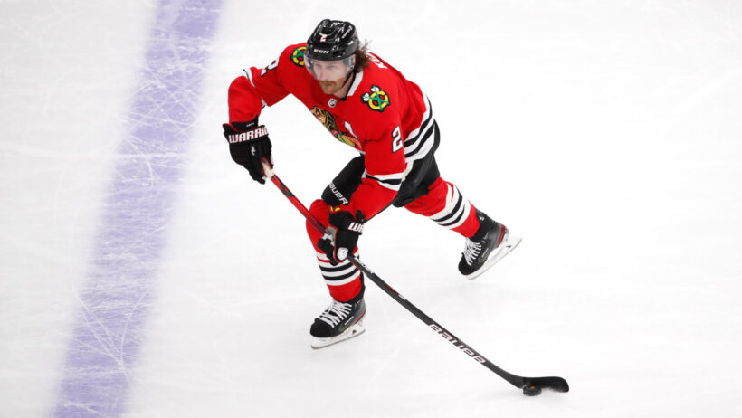 Chicago Blackhawks defenseman Duncan Keith handling the puck on the ice during an NHL game.