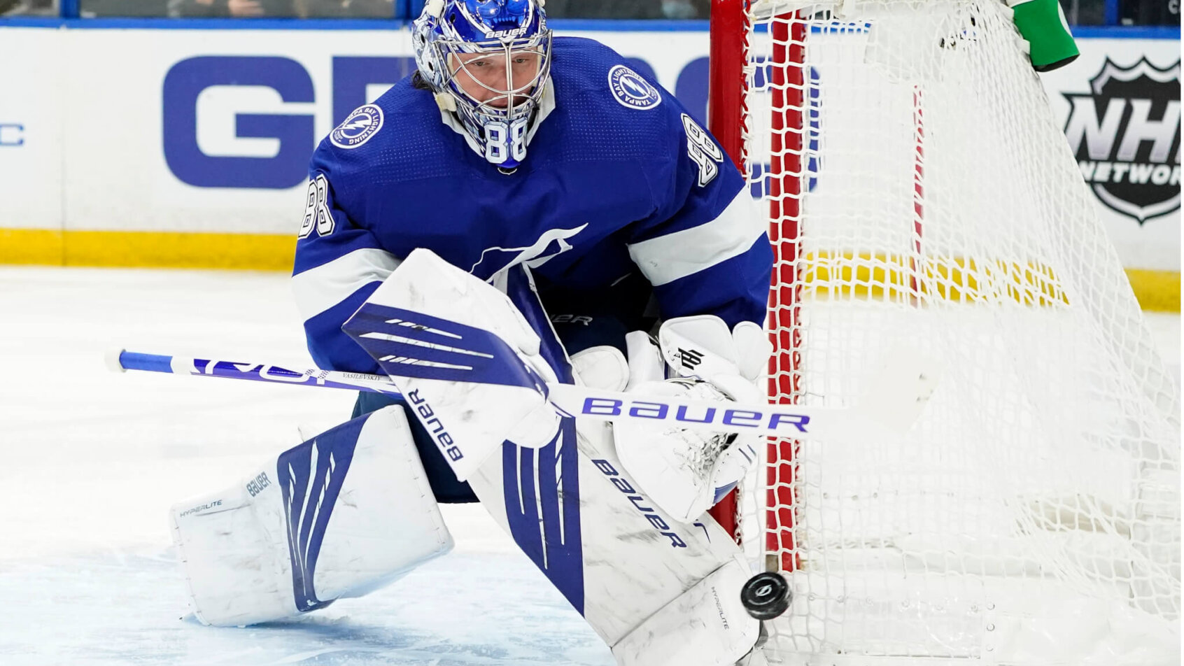 Andrei Vasilevskiy tight against goal post steering puck away