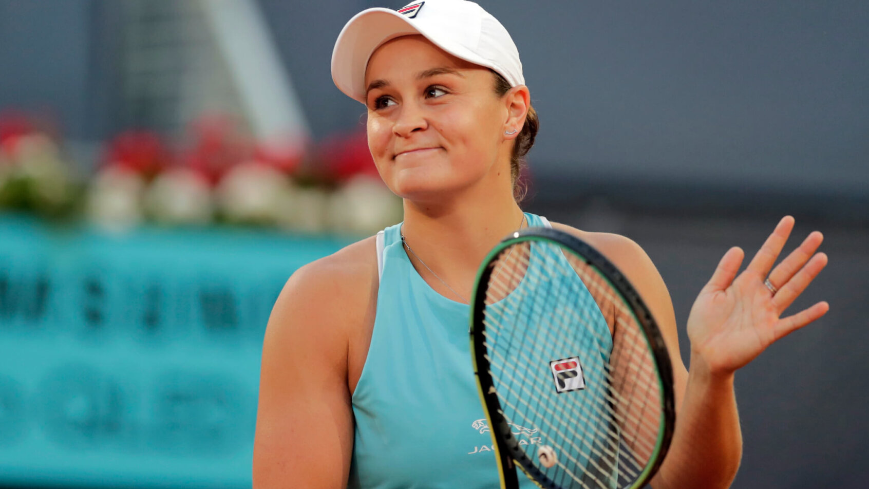 Ashleigh Barty clapping on her racket after winning a tennis match.