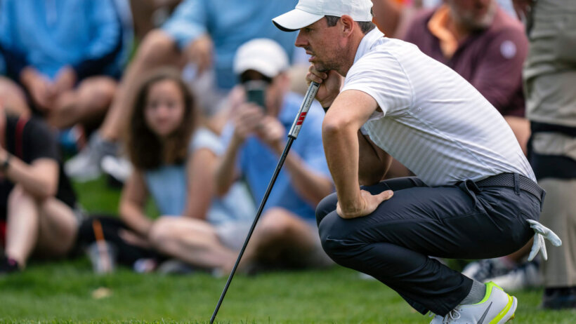 Rory Mcllroy lining up a shot during the third round of a golf tournament.