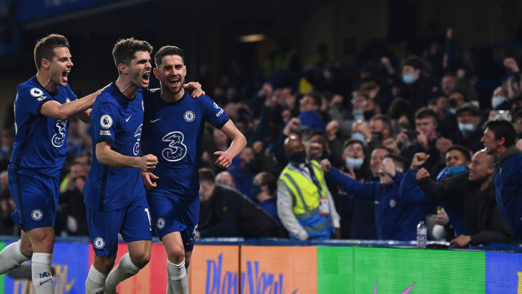Chelsea players celebrating after scoring a goal during a soccer match.