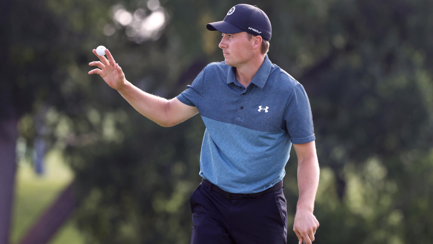 Jordan Spieth waving to fans while on the green during the third round of the Charles Schwab Challenge golf tournament.