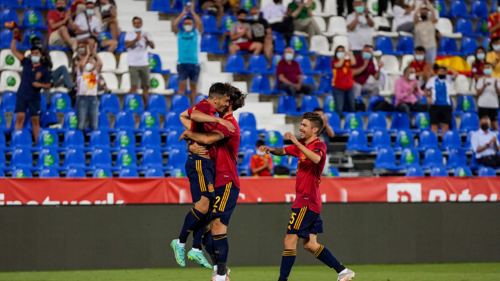 Spain players celebrating after scoring a goal during a soccer match.
