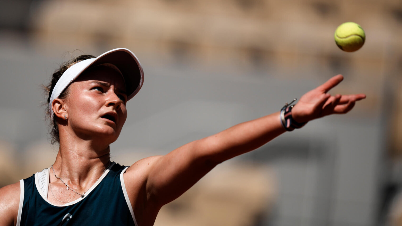 Barbora Krejcikova throwing the ball up to serve during a match at the 2021 French Open.