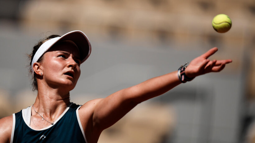 Barbora Krejcikova throwing the ball up to serve during a match at the 2021 French Open.